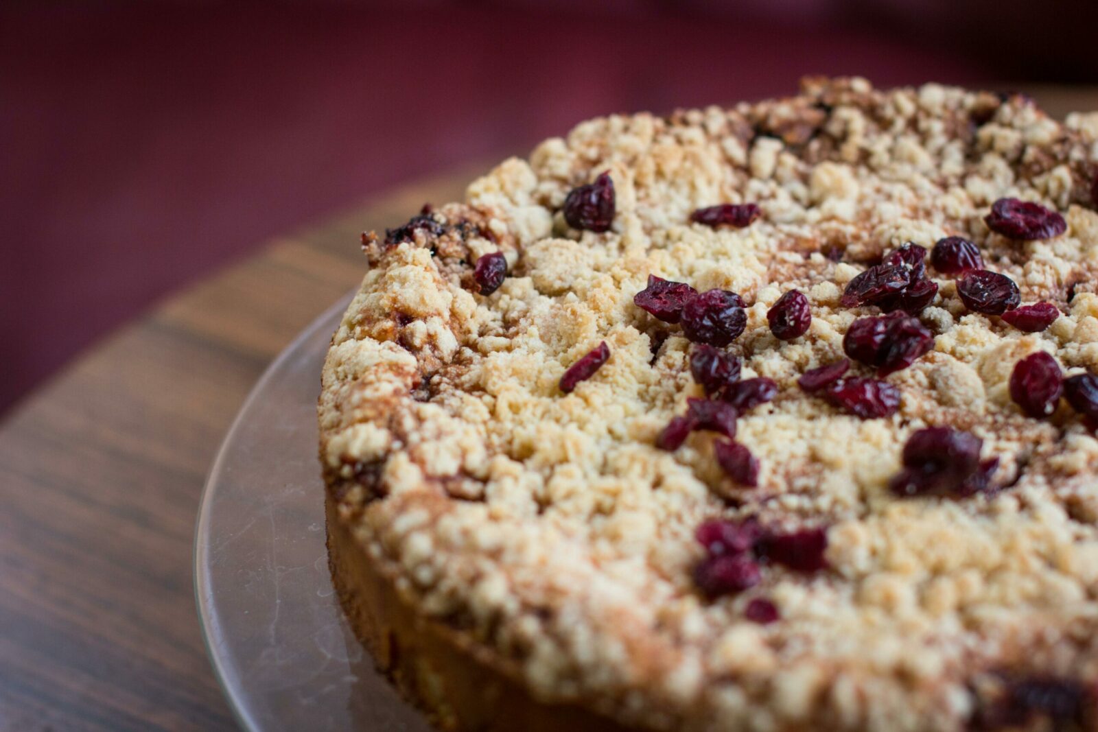 Close-up of a tasty homemade berry crumble cake on a wooden surface, perfect for desserts.