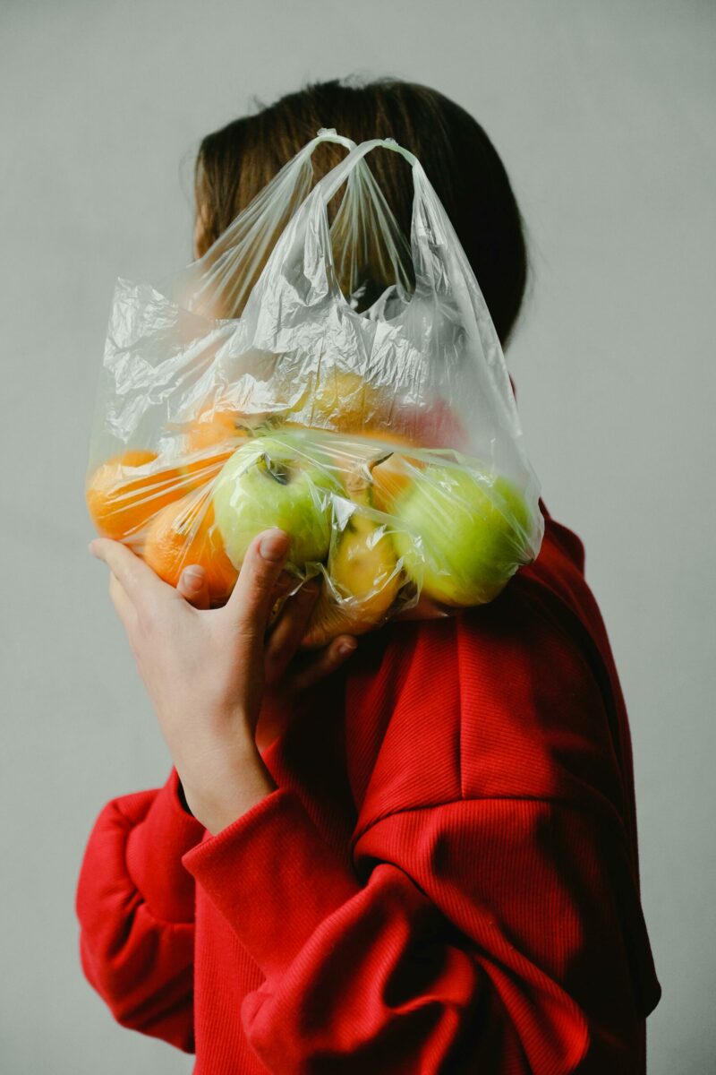 Personne féminin qui porte un sac de fruits sur son épaule